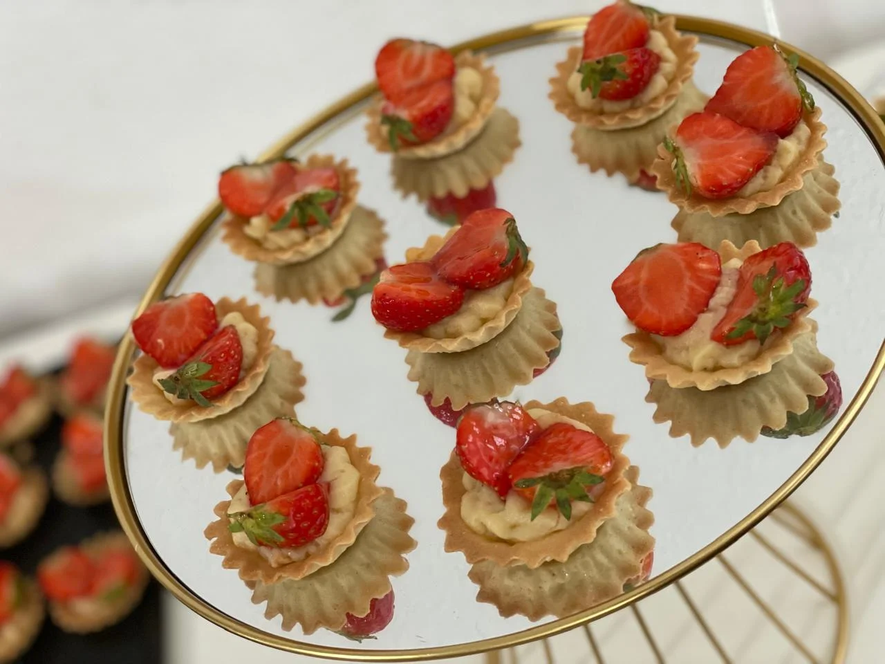 Tartelettes aux fraises présentées sur un plateau miroir